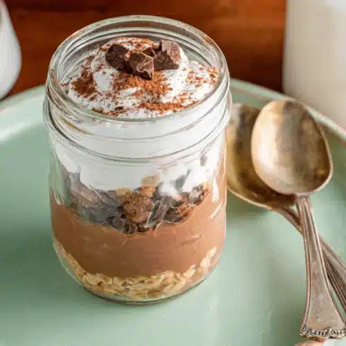 Decadent Oats Overnight Tiramisu: Easy, No-Cook Breakfast 4 Delicious oats overnight tiramisu layered with creamy oats, chocolate, and whipped topping in a mason jar, dusted with cocoa.
