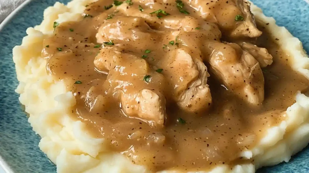 Close-up of chicken and gravy recipe served over mashed potatoes with rich brown gravy