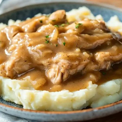 Homemade chicken and gravy recipe served over mashed potatoes with rich brown gravy