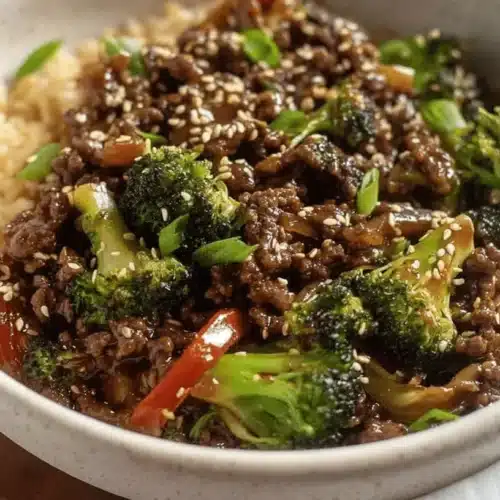 Delicious Ground Beef and Broccoli Stir Fry 2 Close-up of a vibrant ground beef and broccoli recipe, an Asian-inspired rice bowl with red peppers, sesame seeds, and green onions.