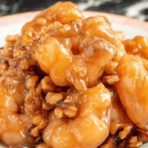 The Best Honey Walnut Shrimp Recipe 2 Close-up of delicious honey walnut shrimp on a decorative plate, glistening with a golden glaze.