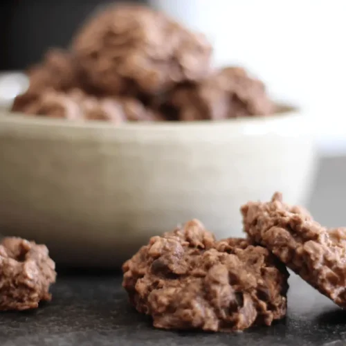 Close-up of rustic chocolate no bake oatmeal cookies on a dark surface.