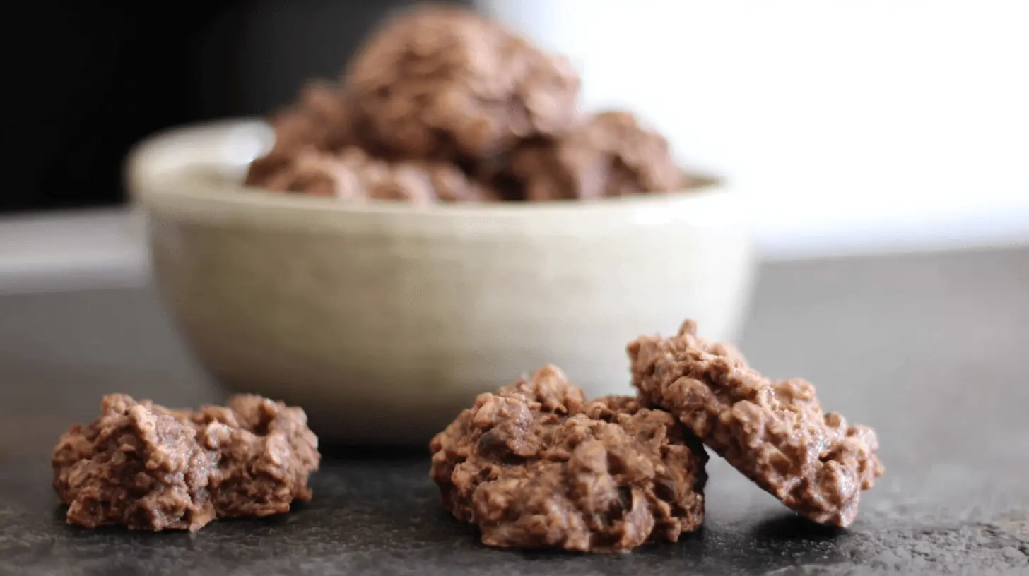 Close-up of rustic chocolate no bake oatmeal cookies on a dark surface.