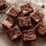 Freshly baked Pecan Pie Brownies with a glossy pecan topping cooling on a wire rack.