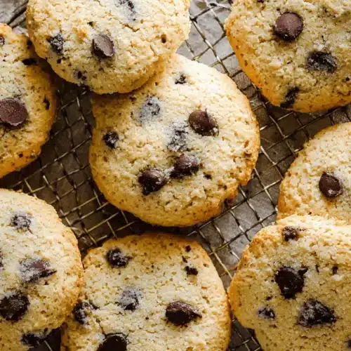 Overhead view of freshly baked chocolate chip cottage cheese cookies on a wire cooling rack.