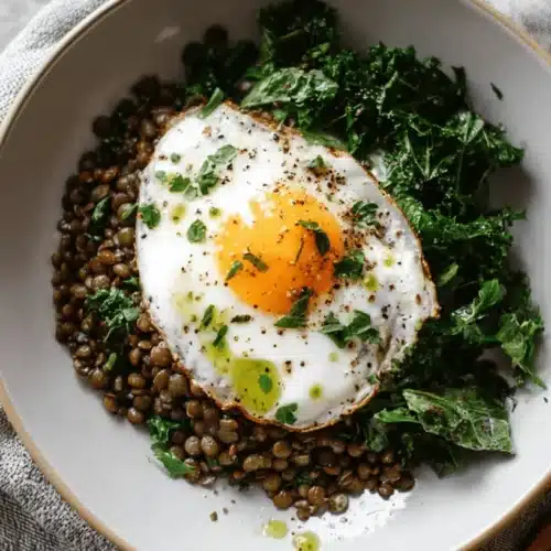 Hearty Lentil Breakfast Bowl with Fried Egg & Kale 2 A vibrant and wholesome Lentil Breakfast Bowl featuring seasoned lentils, sautéed greens, and a perfectly fried sunny-side up egg.