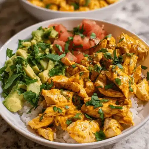 Ultimate Chicken Burrito Bowl: High-Protein & Flavorful Meal Prep 2 Appetizing chicken burrito bowl with rice, avocado, tomatoes, and cilantro on a kitchen counter.