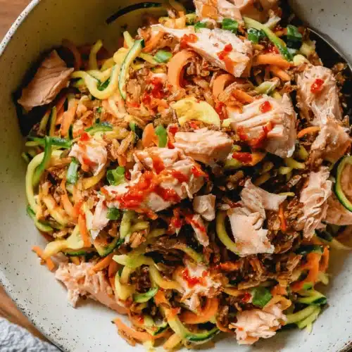 Crispy Rice Salad with Sweet Chili Sauce 2 Vibrant Crispy Rice Salad with Sweet Chili Sauce, fresh salmon, spiralized vegetables, and green onions in a rustic bowl.