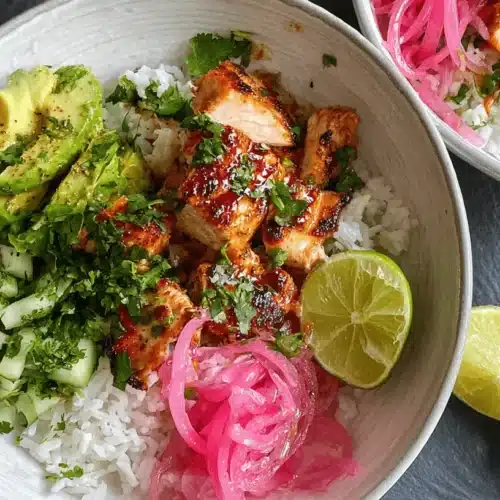 Honey Lime Chicken and Rice Bowls 2 Overhead view of vibrant Honey Lime Chicken & Rice Bowls with avocado, pickled onions, and fresh cilantro.