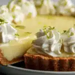 A close-up shows a delicious key lime pie with a slice being served, revealing its creamy filling, graham cracker crust, and whipped cream topping.