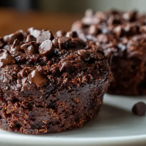 High-Protein Chocolate Quinoa Muffins: Healthy & Delicious! 2 High-Protein Chocolate-Quinoa Muffins topped with chocolate chips on a white plate.
