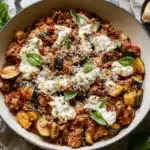 Vibrant Ground Turkey and Zucchini Skillet with melted cheese, fresh basil, and crusty bread, served in a cast iron pan.