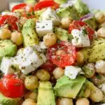 Vibrant close-up of Healthy Chickpea Feta Avocado Salad in a rustic bowl, featuring fresh avocado, chickpeas, tomatoes, and crumbled feta cheese.